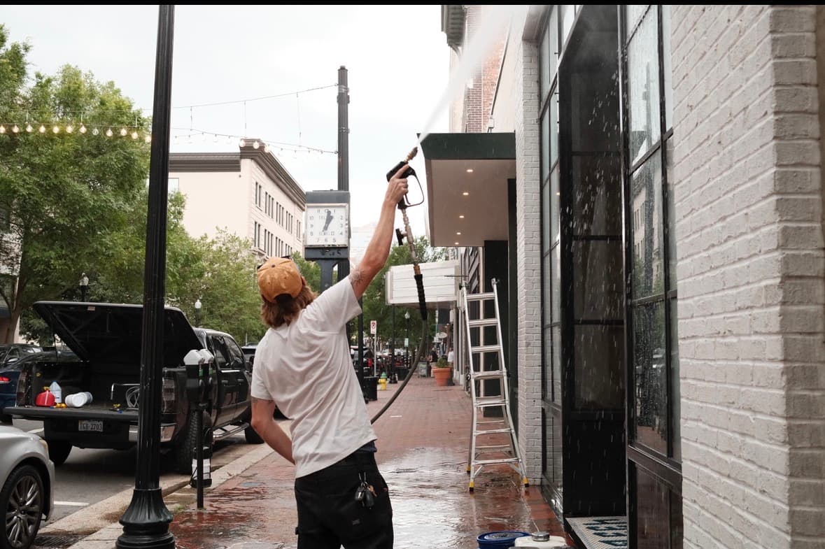 Exterior cleaning in progress on a commercial storefront
