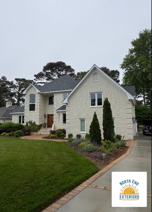 Large brick home with a manicured lawn and driveway