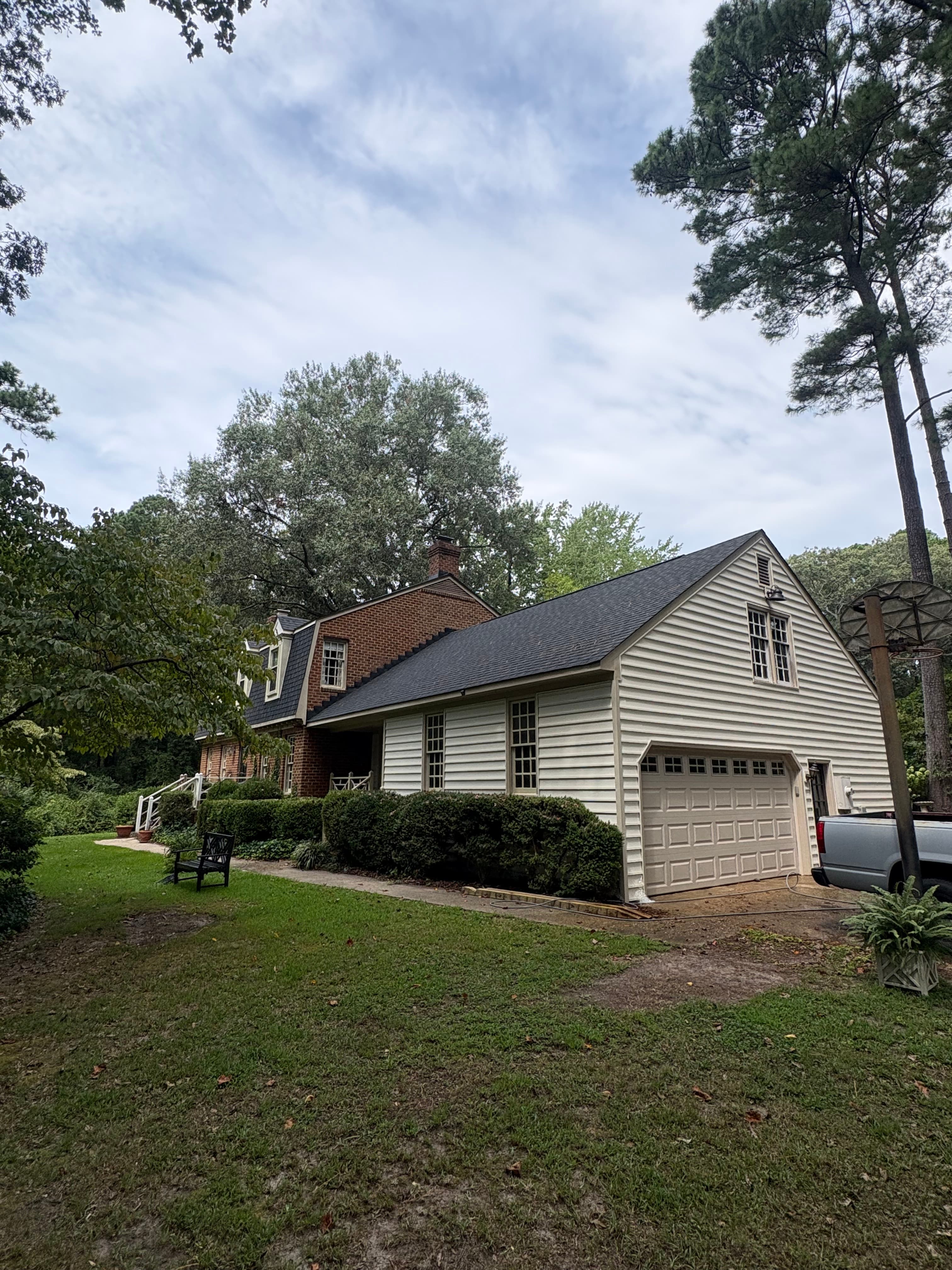 Traditional home exterior with a front lawn and mature trees